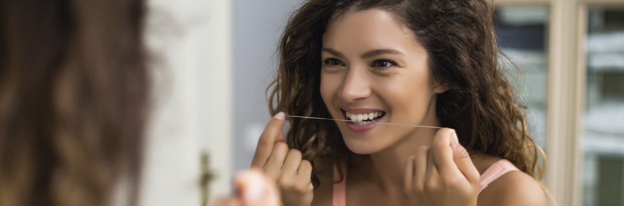 woman-flossing-in-mirror-1242x411.png