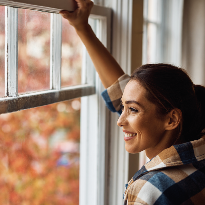 woman-smiling-looking-out-window-800x800.png