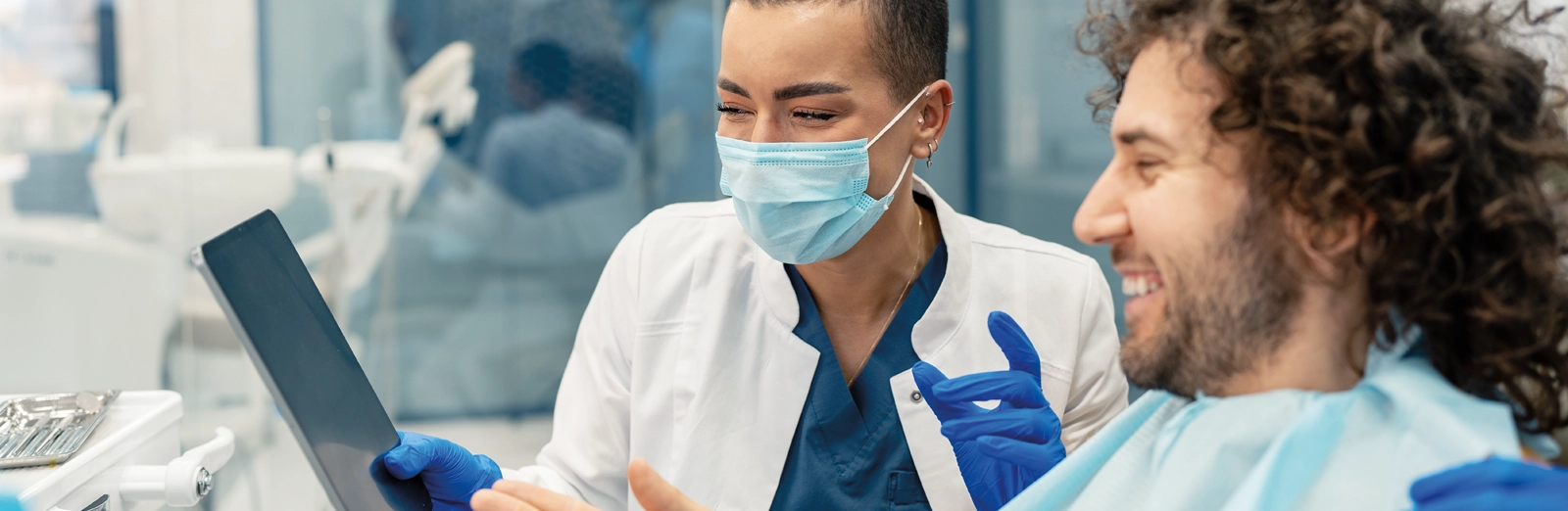 dentist-and-patient-looking-at-tablet-1600x522.webp