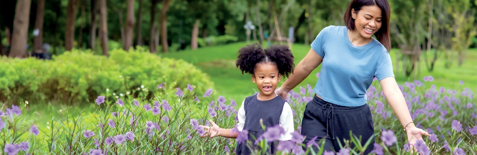 mom-and-daughter-walking-through-flowers-1600x522.webp