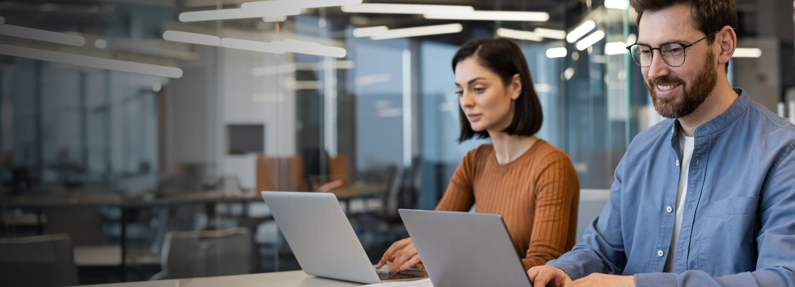 man-and-woman-working-in-office-on-laptops-1600x578-ALT.webp