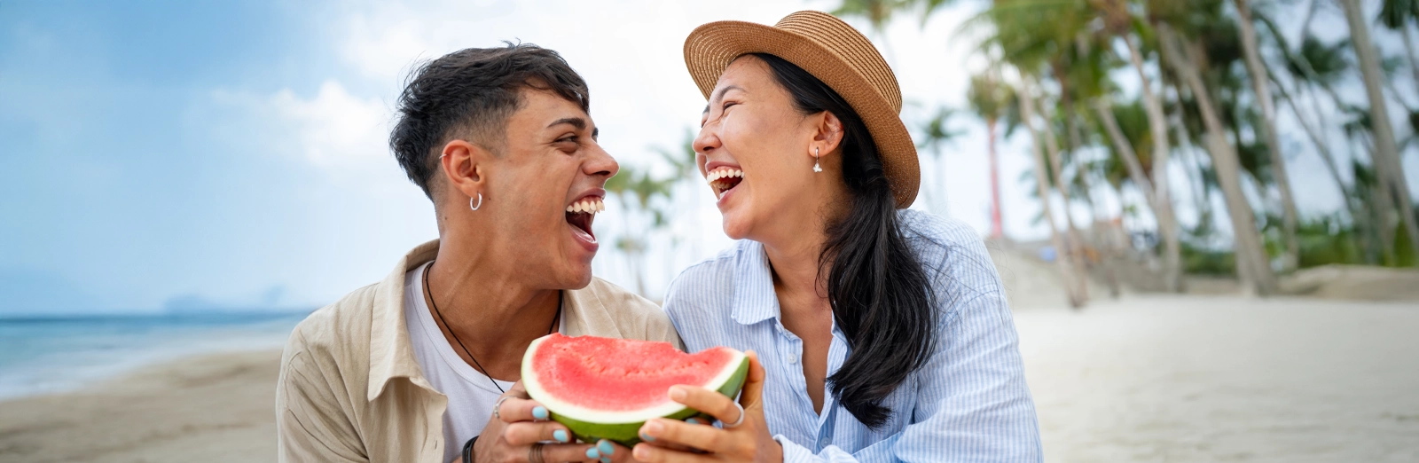 couple-smiling-while-eating-watermelon-1600x522.webp