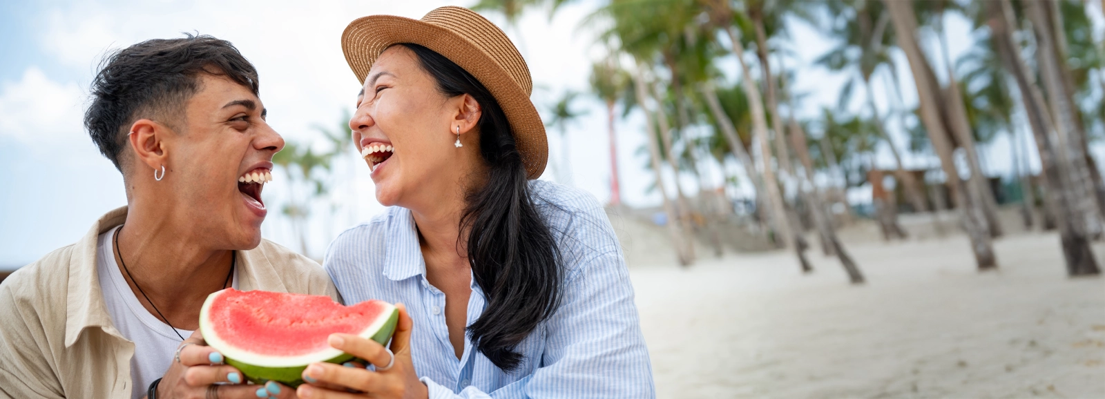 couple-smiling-while-eating-watermelon-1600x578.webp