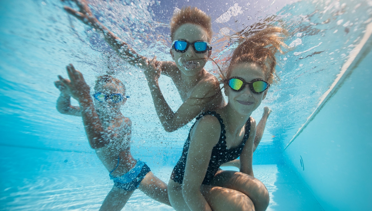 three-young-kids-swimming-underwater-1200x683.webp