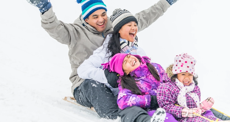 family-laughing-and-sledding-752x400.webp