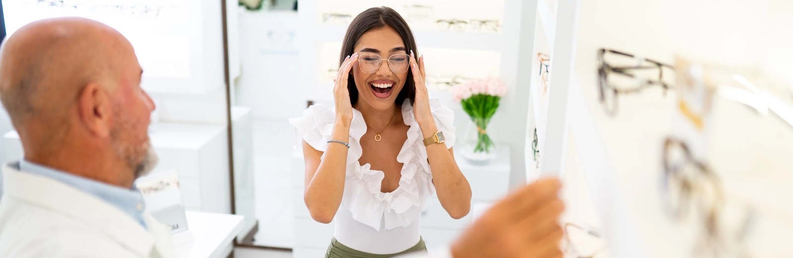 woman-smiling-in-glasses-at-optometrist-1600x522.webp