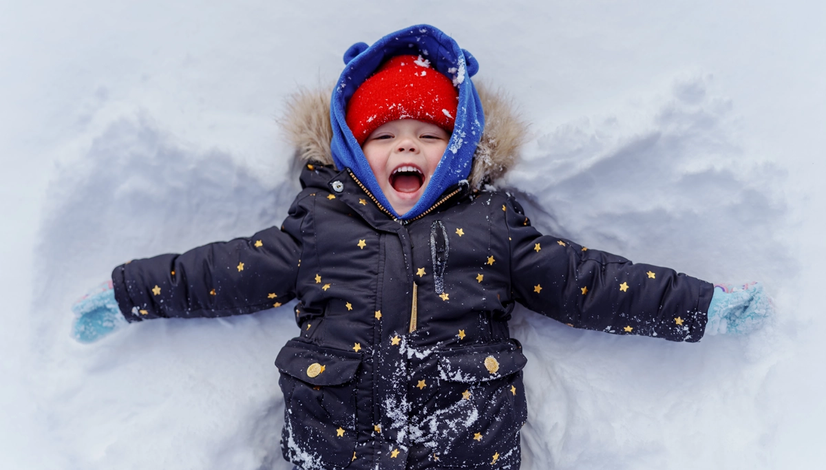 young-boy-laying-in-the-snow-1200x683.webp