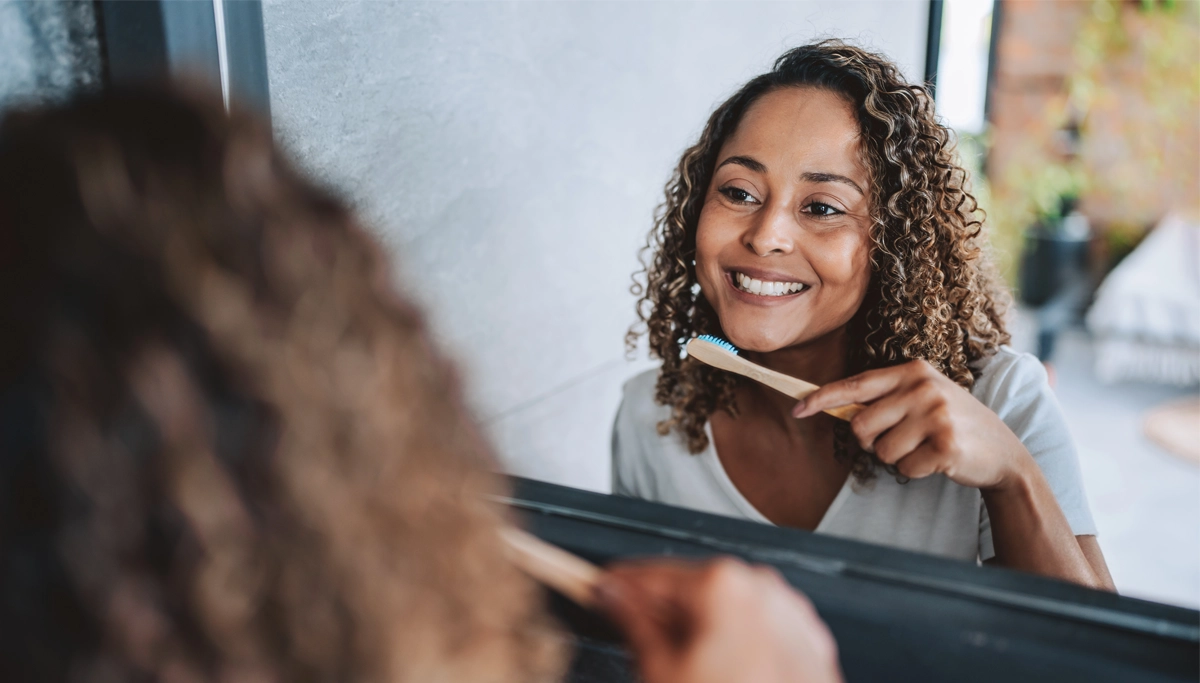 woman-smiling-while-brushing-teeth-1200x683.webp